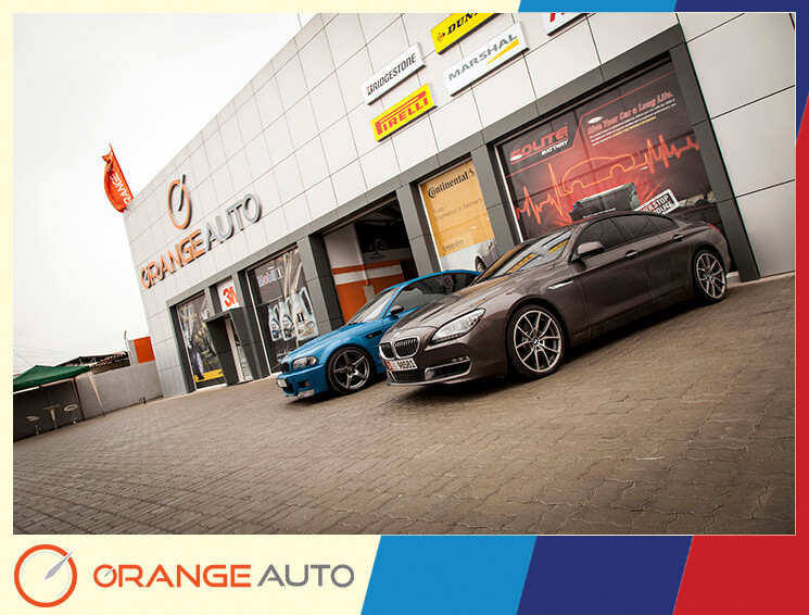 Blue and brown BMW's in an Orange Auto garage