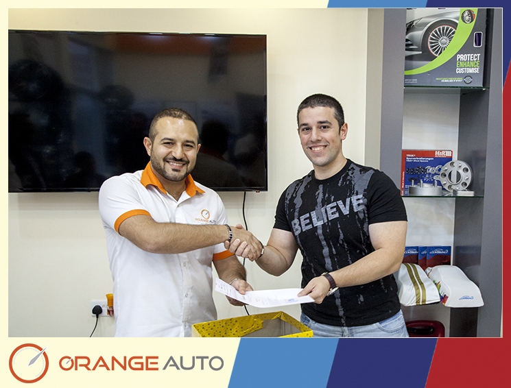 An expert giving a certificate at Orange Auto center