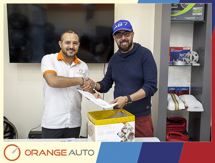 A worker with a man in A8 L cap at Orange Auto center